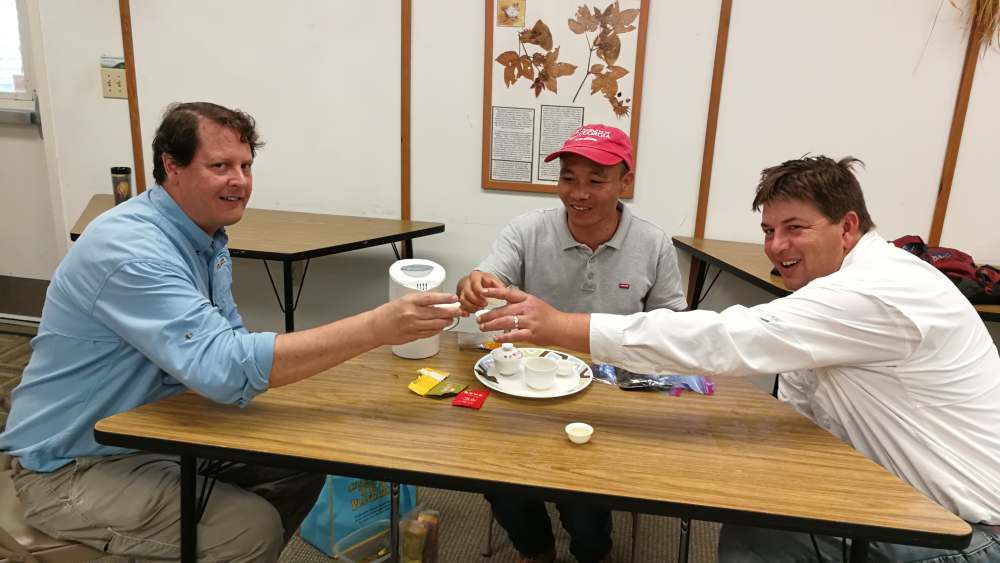 Thomas Zhilong Joshua tea cheers smiling.jpg